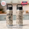 Tan water bottle with brown paw prints. Design: a black and white dog in a cowboy hat and bandana. Text: 