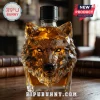 Crystal glass decanter shaped like a geometric wolf head containing amber liquid on a dark wooden table!