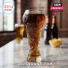 Soccer trophy shaped glass filled with amber beer, sitting on a marble table with a blurred pub background.!
