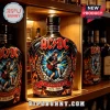 AC/DC 50th anniversary black glass liquor bottle with Angus Young illustration, lightning, and fire motifs on shelf.!