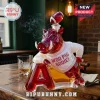 Red glass hog whiskey decanter wearing a white sweater with WOO PIG SOOIE text and a football stopper on a wooden table.!