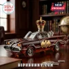 Amber glass Batmobile liquor decanter with a gold crown topper and a 60th Anniversary badge on a wooden desk.!