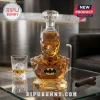 Batman-shaped glass decanter filled with amber liquid, featuring a crystal stopper, sitting on a glass table with a cigar.!