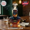 Batman-shaped glass whiskey decanter with a diamond-cut stopper on a wooden table next to a crystal rocks glass.!