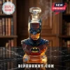 Batman-shaped glass whiskey decanter with a diamond-cut stopper and yellow bat logo on a black marble table surface.!