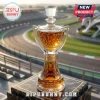 Crystal Bill France Cup whisky decanter on a marble base with gold accents in front of a blurred race track background.!