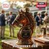 Amber glass horse head decanter with gold bridle details, topped by a metal horse and jockey figurine on a wooden table.!