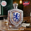 Crystal decanter with shield shape featuring a blue Chelsea FC lion logo, standing on a wooden table with whiskey glass.!