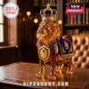 Amber glass lion figurine wearing a gold crown and purple velvet cape with a Crown Royal shield emblem on a desk.!