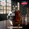 Daft Punk helmet shaped glass whiskey decanter with silver chrome finish and amber liquid interior on wooden bar table.!