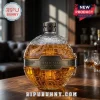 Death Star shaped glass whiskey decanter with gold-toned metal plaque reading Death Star 50th Anniversary on wooden table.!