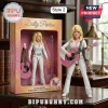 Dolly Parton action figure in a white rhinestone jumpsuit with a pink acoustic guitar and microphone stand in a box.!