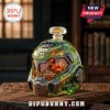 Doom Slayer helmet shaped green glass decanter with 33rd anniversary text on a wooden table.!