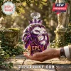 Crystal English Premier League lion head decanter with purple facets, held in hand outdoors on a stone path.!