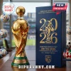 Gold FIFA World Cup 2026 commemorative trophy bottle with soccer ball stopper next to a dark blue display box on a desk.!