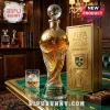 FIFA World Cup 2026 commemorative gold and glass decanter with soccer ball stopper, next to a matching gift box on a desk.!