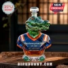 Faceted crystal alligator whiskey decanter wearing a blue and orange jersey with 120th anniversary text on wooden table.!