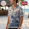 Man wearing a cream button-down shirt with blue vintage Ford Mustang illustrations, Route 66 motifs, and car dashboard art.!