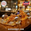 Formula 1 race car shaped glass whiskey decanter with a gold crown topper, sitting on a wooden bar surface.!