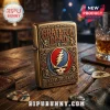 Grateful Dead themed brass metal lighter with embossed Steal Your Face logo and dancing bears on a wooden bar table.!