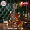 Grateful Dead 60th anniversary guitar-shaped glass whiskey decanter with dancing bear and rose designs on a wooden bar.!