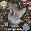 Crystal swan-shaped vodka decanter on wooden surface with metal compass, flask, and white blossoms.!