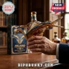 Milano starship shaped glass whiskey decanter filled with amber liquid held in a hand before a matching product box.!