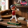 Ha-Seong Kim baseball bobblehead wearing a red jersey, white pants, and orange visor on a green base on a wooden shelf.!