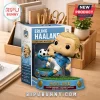 Erling Haaland vinyl figure kicking a soccer ball on a grass base with a matching blue and white display box on a desk.!
