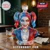 Faceted crystal Harley Quinn bust decanter with red and blue accents on a wooden table with a glass of whiskey.!