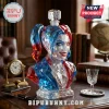 Harley Quinn bust decanter made of faceted red and blue crystal with a heart-shaped stopper on a wooden desk.!