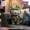Hello Kitty plush wearing green Master Chief Spartan armor with a yellow visor, sitting on a gray fabric sofa.!