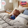 Brown Hello Kitty plush wearing a blue New York number 11 basketball jersey sitting on a beige bed with pillows.!