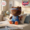 Brown Hello Kitty plush wearing an Oklahoma City Thunder basketball jersey, headband, and sneakers sitting on a bed.!