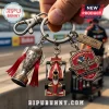 Indy 500 keychain set featuring a Borg-Warner trophy charm, red race car, and 110th anniversary logo badge on metal ring.!