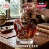 Iron Maiden Trooper crystal whiskey decanter with red faceted body, skeletal head, and glass stopper on wooden desk.!