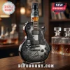 Jack Daniel's guitar-shaped whiskey bottle with silver skull, rose engravings, and Slash signature on a wooden bar counter.!