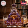Purple and gold glass decanter shaped like a bulldog wearing a crown with GO DUKES and JMU text on a wooden desk.!