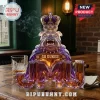 Faceted purple and gold glass bulldog decanter wearing a crown with GO DUKES! text on a wooden table with a whiskey glass.!