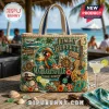 Jimmy Buffett Margaritaville tote bag with parrot, guitar, ship wheel, and seashell embellishments on a beach table.!