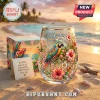 Stemless wine glass with macaw, hibiscus flowers, and text It's Five O'Clock Somewhere on a beach background.!
