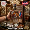 Jose Cuervo Grateful Dead tequila bottle with silver skull emblem, matching glasses, and wooden box on a black counter.!