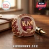 Kappa Alpha Psi fraternity gold ring featuring a large red center stone, KΑΨ lettering, and diamond accents on wood desk.!