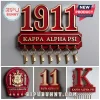 Kappa Alpha Psi wooden wall key holder with red and gold 1911 text and seven brass hooks on a grey background.!