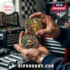 Kyle Busch NASCAR commemorative gold and blue metal coins held in hands against a blurred workshop background.!