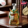 Gundam-shaped glass decanter in white and green with gold accents and REANIMATION 24TH ANNIVERSARY text on wooden desk.!