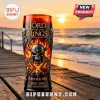 Lord of the Rings 25th anniversary glass tumbler with skull helmet and flame design on a wooden pier at sunset.!