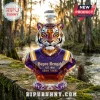 Faceted tiger-shaped glass decanter in purple and gold with Bayou Bengals Est. 1893 Geaux Tigers text on a stone ledge.!