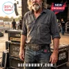 Man wearing a Lynyrd Skynyrd belt buckle with skull and wings design, standing on a concert stage with music gear.!
