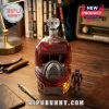 M.A.S.K. themed red glass whiskey decanter with metal faceplate on a wooden desk with a vintage action figure.!